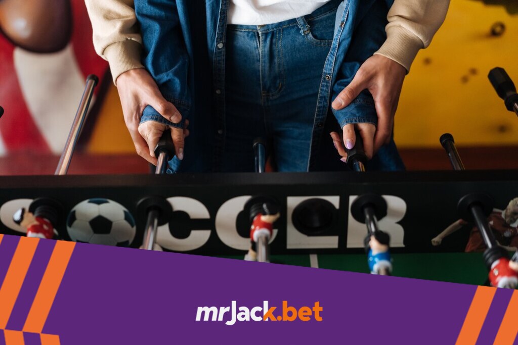 Handicap: entenda como potencializar seus ganhos com essa estratégia 6 Pessoa com casaco girando os jogadores de uma mesa de pebolim.