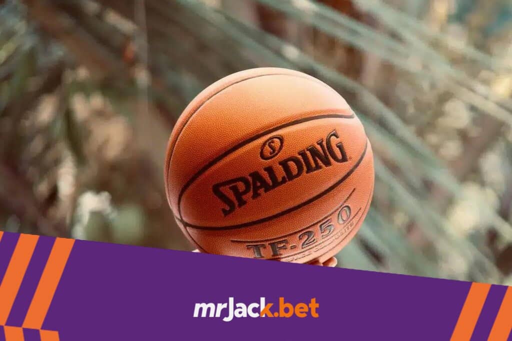 Handicap no basquete: aprenda a apostar com essa estratégia de vantagens e desvantagens em pontos 5 Mão esquerda de uma pessoa, com um relógio o pulso, segurando uma bola de basquete laranja por baixo.