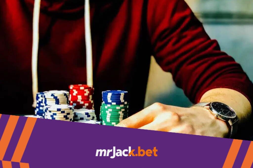 Banca de apostas: o que é e como cuidar bem da sua 5 Pessoa de blusa vermelha com duas cartas de cabeça para baixo, e diversas fichas de poker.