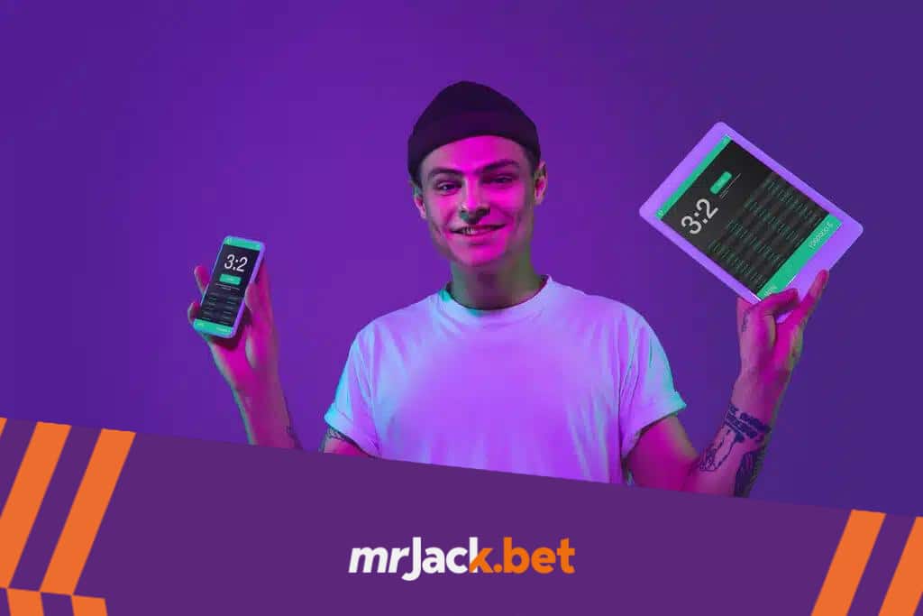O que é bookmaker e como funciona no mundo das apostas? 4 Homem de blusa branca e gorro preto segurando um tablet em uma mão, e um celular na outra.